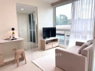 Bright modern living room with large window and cozy sofa, perfect for relaxation.