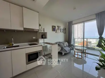 Modern open-layout kitchen and living room with city view and balcony access.