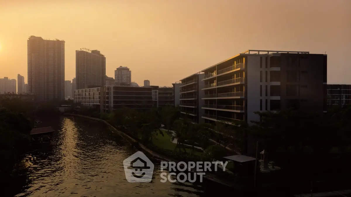 Stunning riverside view of modern apartment buildings at sunset, perfect for urban living.