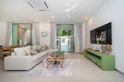 Spacious modern living room with pool view, elegant decor, and ample natural light.