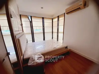 Cozy bedroom with large windows and air conditioning in modern apartment