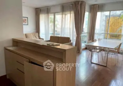 Spacious living room with large windows and modern furniture in a bright apartment.