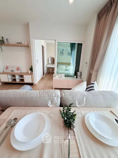 Modern open-plan living room with dining area and view into cozy bedroom