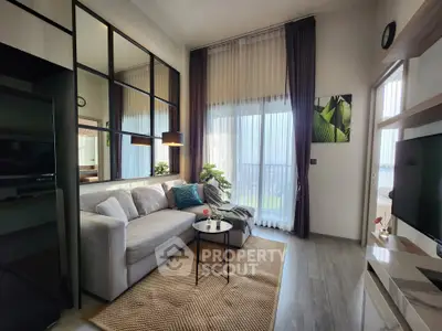 Modern living room with large windows, stylish decor, and cozy seating area.