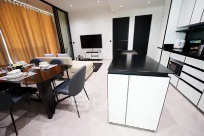 Modern open-plan kitchen and living area with sleek design and dining table.