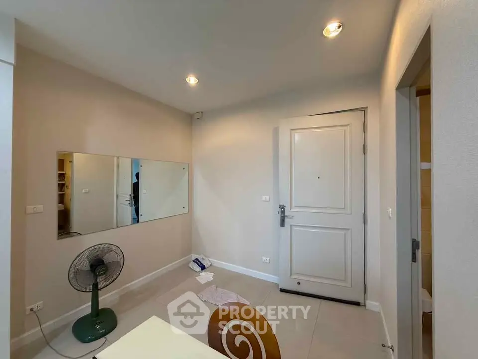 Cozy interior with modern decor and neutral tones, featuring a stylish mirror and sleek lighting.