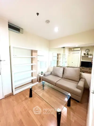 Cozy living room with modern sofa and glass coffee table, perfect for relaxation.