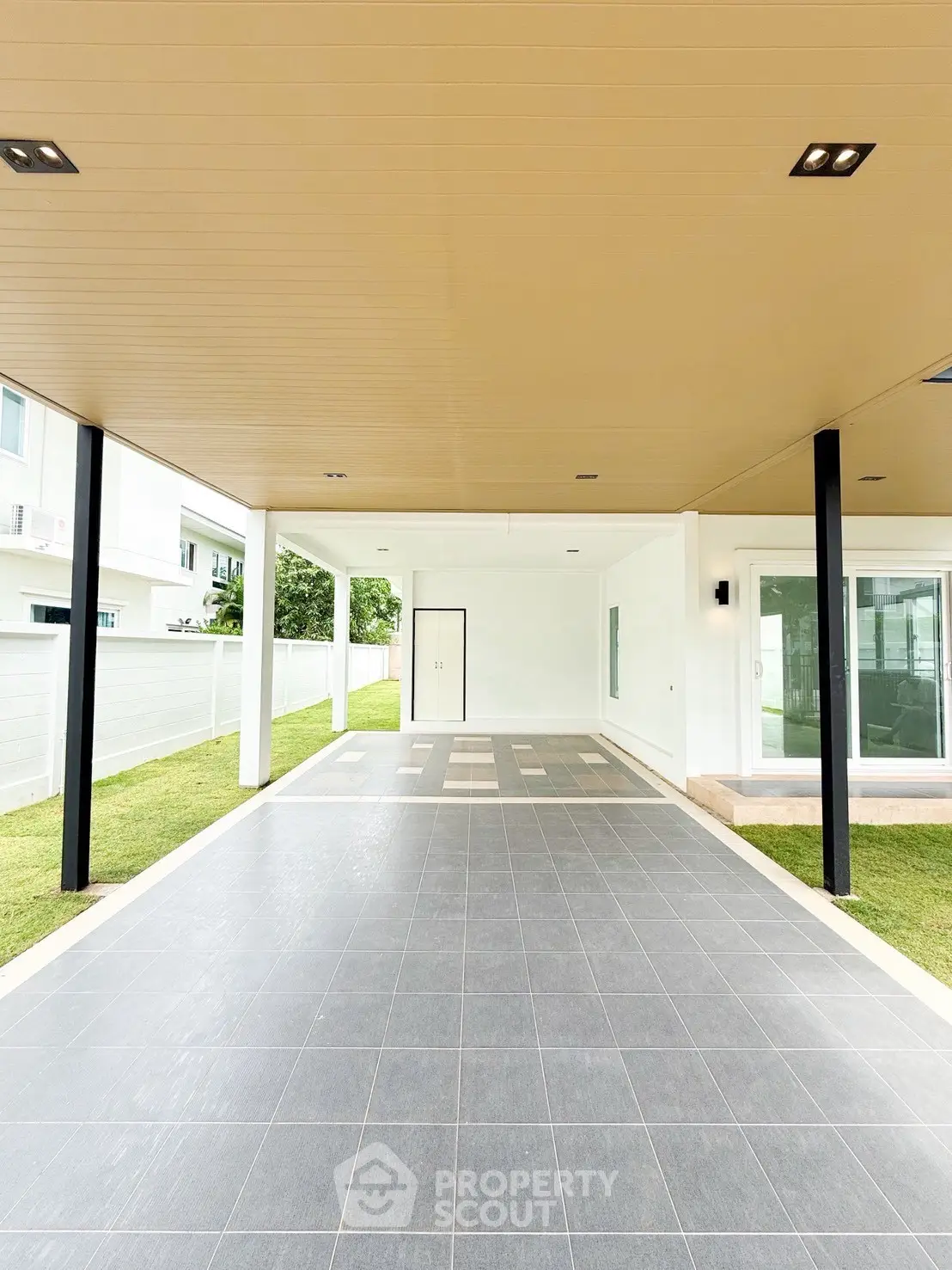 Spacious modern carport with sleek design and tiled flooring in a contemporary home.