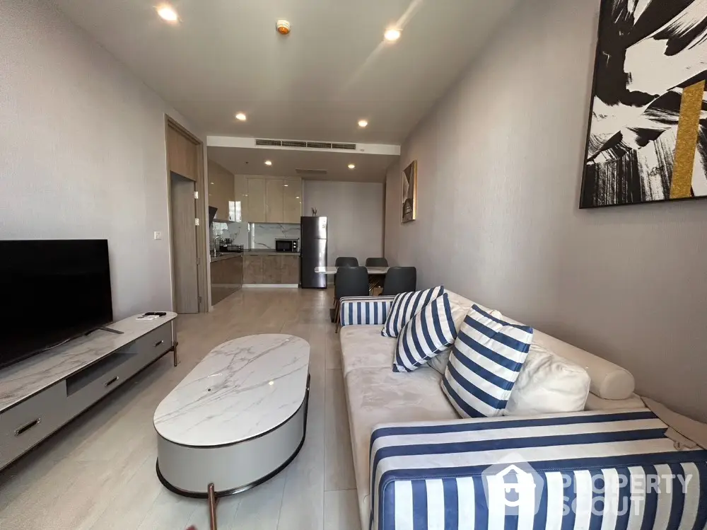 Modern living room with stylish furniture and open kitchen layout in a contemporary apartment.