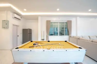 Spacious living room with pool table and modern decor, perfect for entertainment.