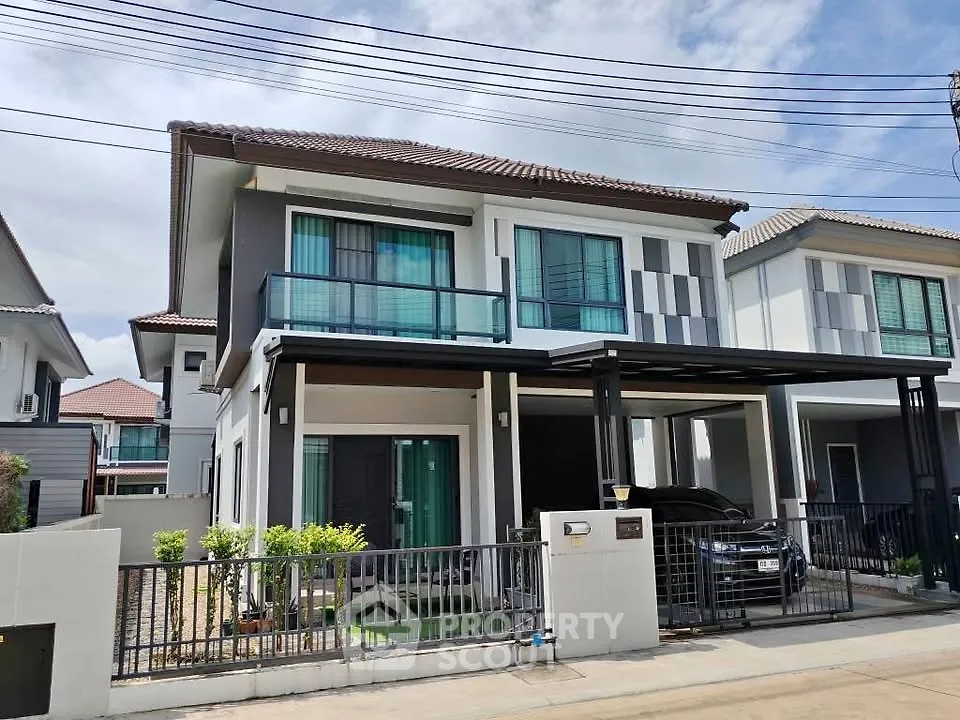 Modern two-story house with sleek design and spacious driveway in a suburban neighborhood.