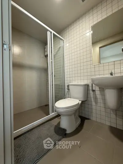 Modern bathroom with glass shower and sleek fixtures in a contemporary apartment.