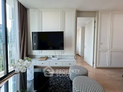 Modern living room with elegant decor and large TV, featuring stylish furniture and a city view.