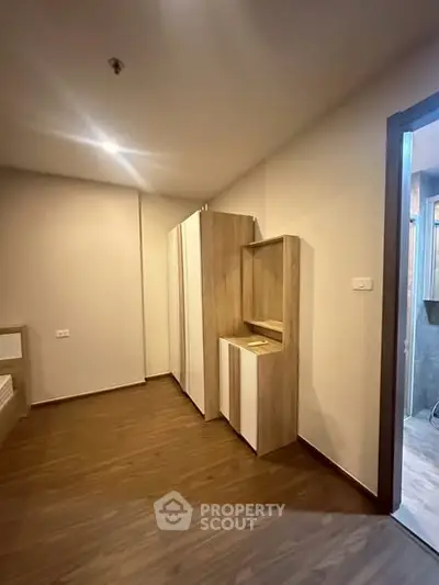 Modern bedroom with wooden flooring and built-in wardrobe in a stylish apartment.