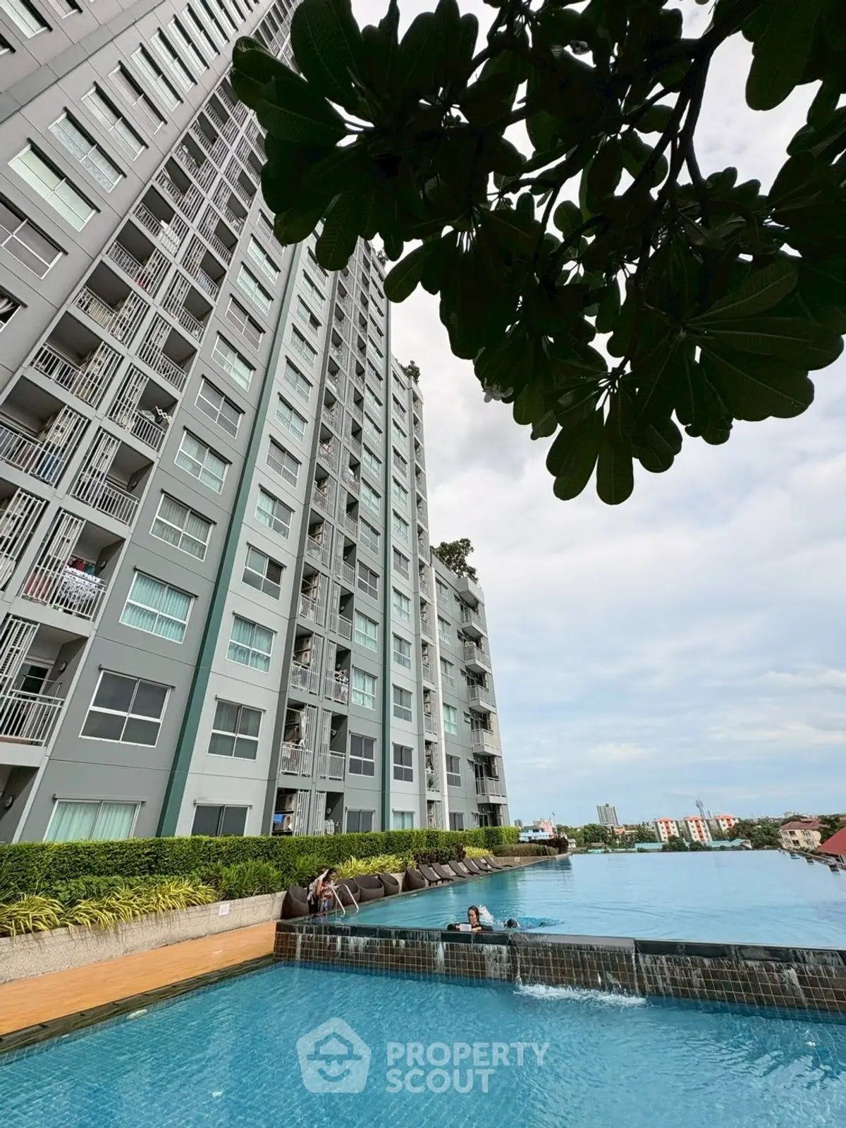 Modern high-rise building with luxurious pool and city views, perfect for urban living.