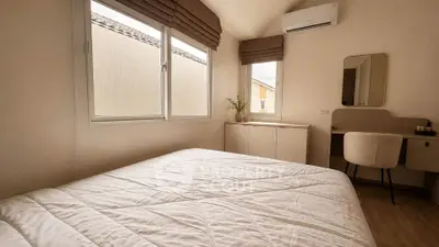 Cozy bedroom with large windows and modern furnishings, perfect for relaxation and comfort.