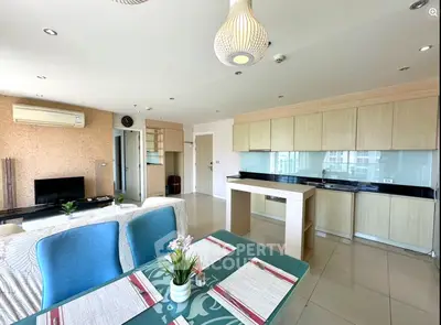 Spacious open-plan living room and kitchen with modern decor and ample natural light.