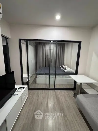 Modern studio apartment with glass partitioned bedroom and sleek furnishings