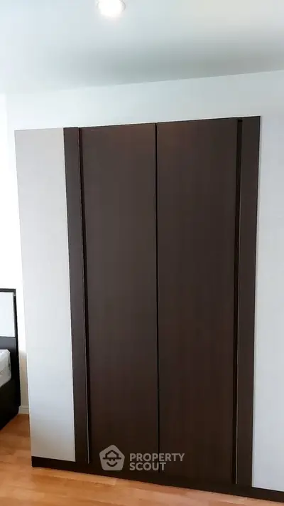 Modern bedroom with sleek wooden wardrobe and minimalist design
