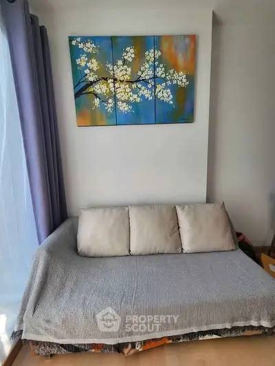 Cozy living room with stylish sofa and vibrant wall art, perfect for relaxation.