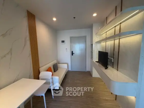 Modern living room with sleek design, featuring a wall-mounted TV, stylish sofa, and elegant lighting.