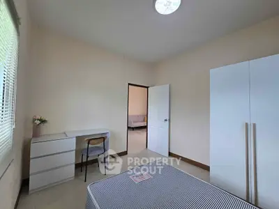 Spacious bedroom with modern furniture and ample natural light