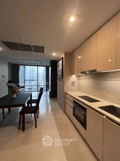 Modern open-layout kitchen with sleek cabinetry and dining area, offering a stylish and functional living space.