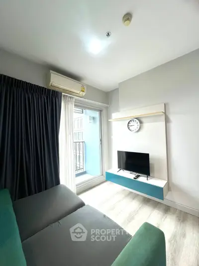 Modern living room with sleek TV setup and large window for natural light.