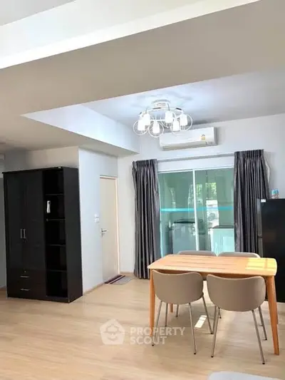 Bright modern living room with dining area and balcony access, featuring stylish furniture and natural light.