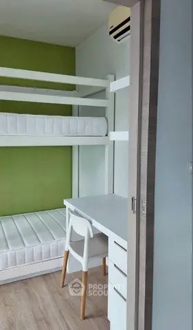 Modern compact bedroom with bunk beds and study desk, ideal for maximizing small spaces.