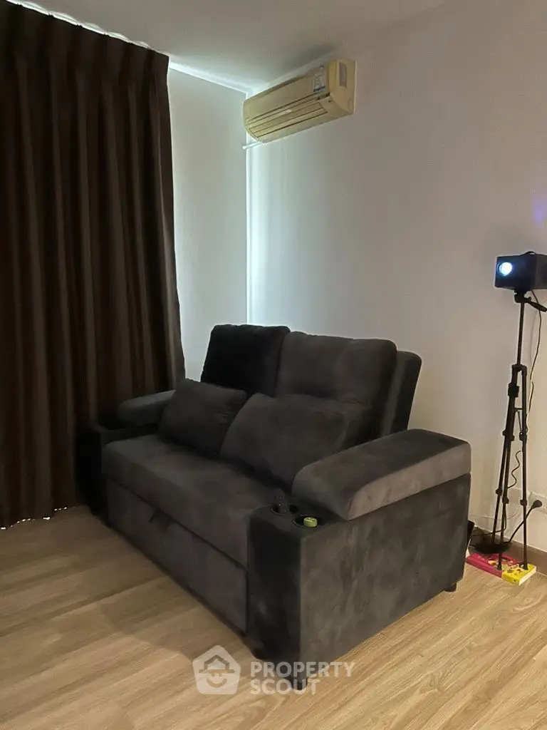 Cozy living room with plush sofa and modern air conditioning unit.