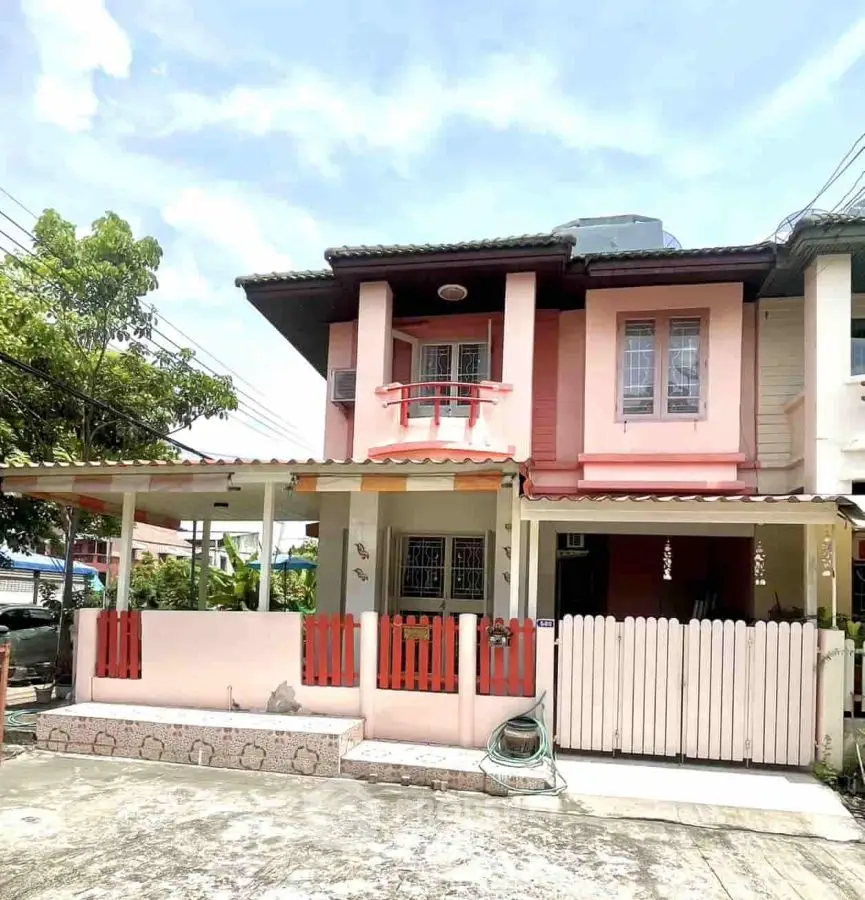 Charming two-story house with balcony and fenced yard in a serene neighborhood.