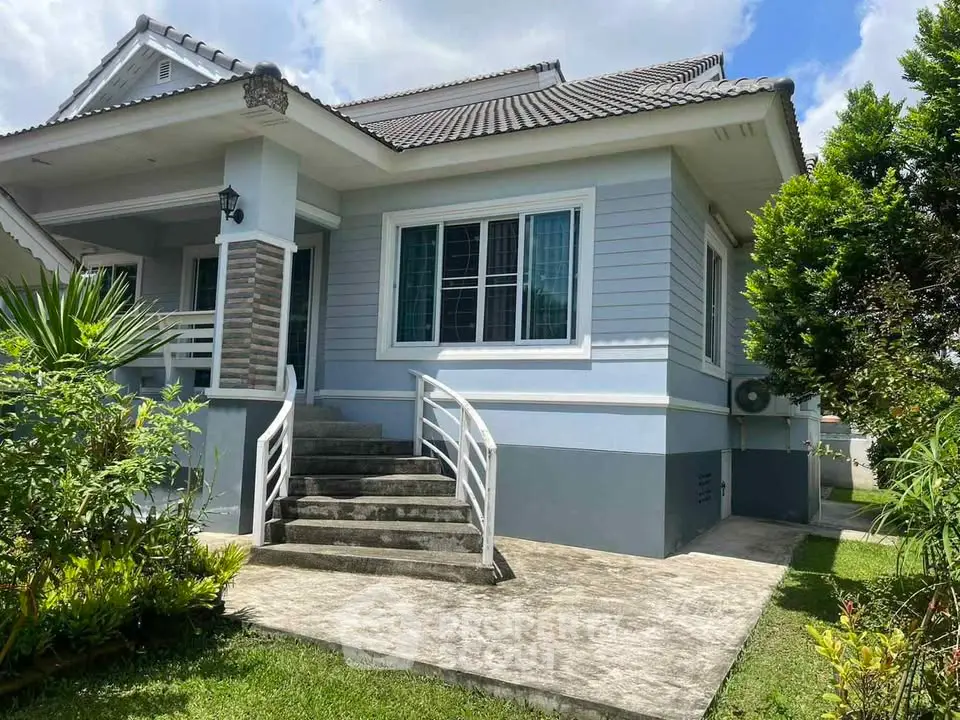 Charming single-story house with lush garden and inviting entrance