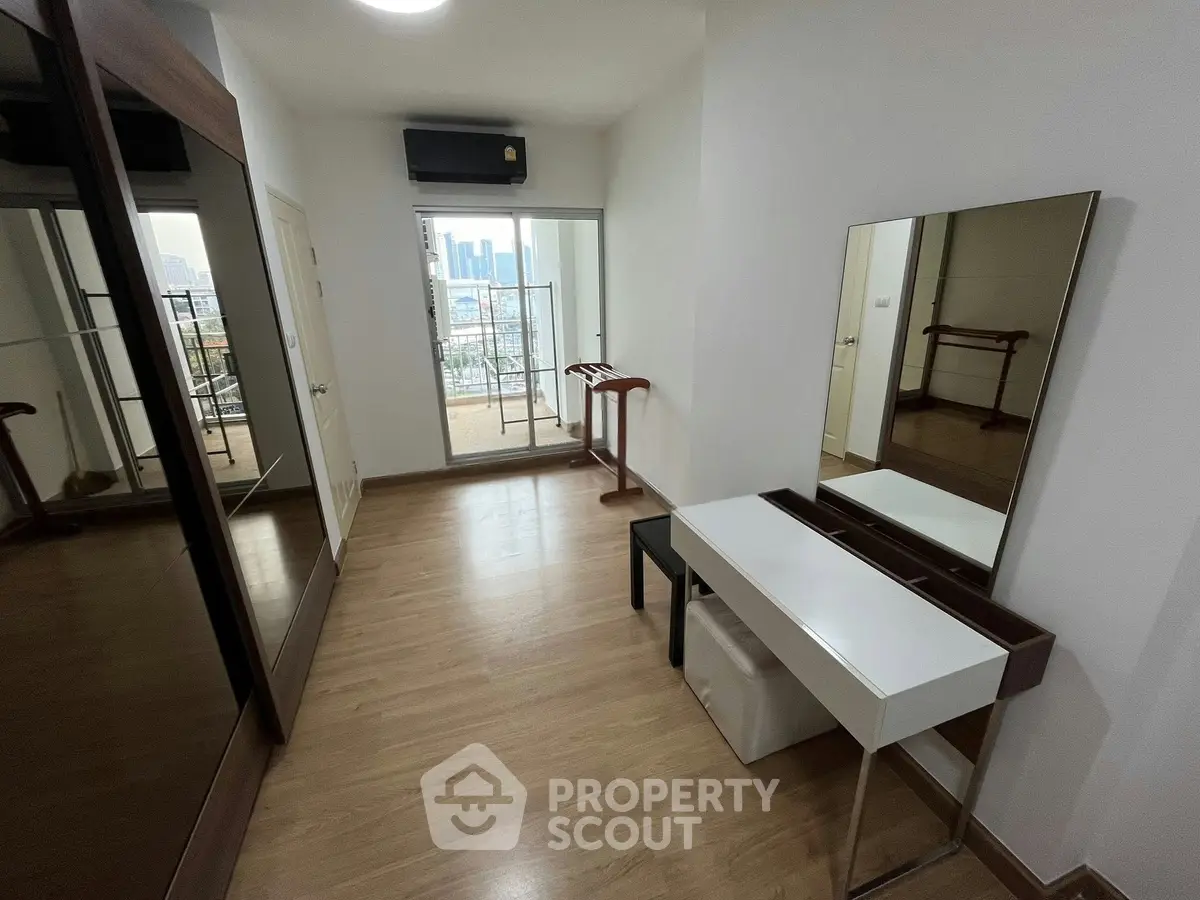 Spacious bedroom with balcony access and modern furnishings in urban apartment