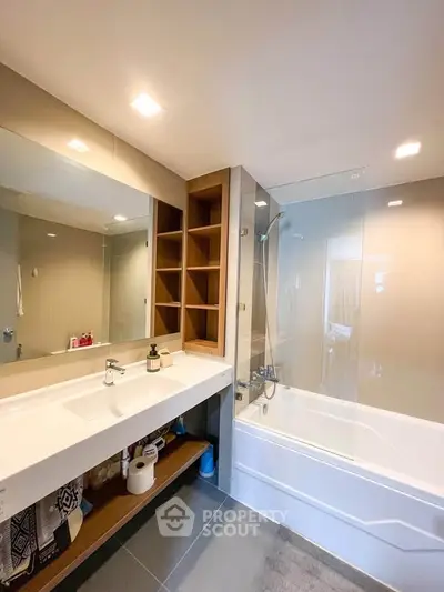 Modern bathroom with sleek design, featuring a bathtub and spacious vanity area.