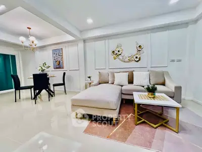 Spacious modern living room with elegant decor and dining area, featuring plush seating and stylish lighting.