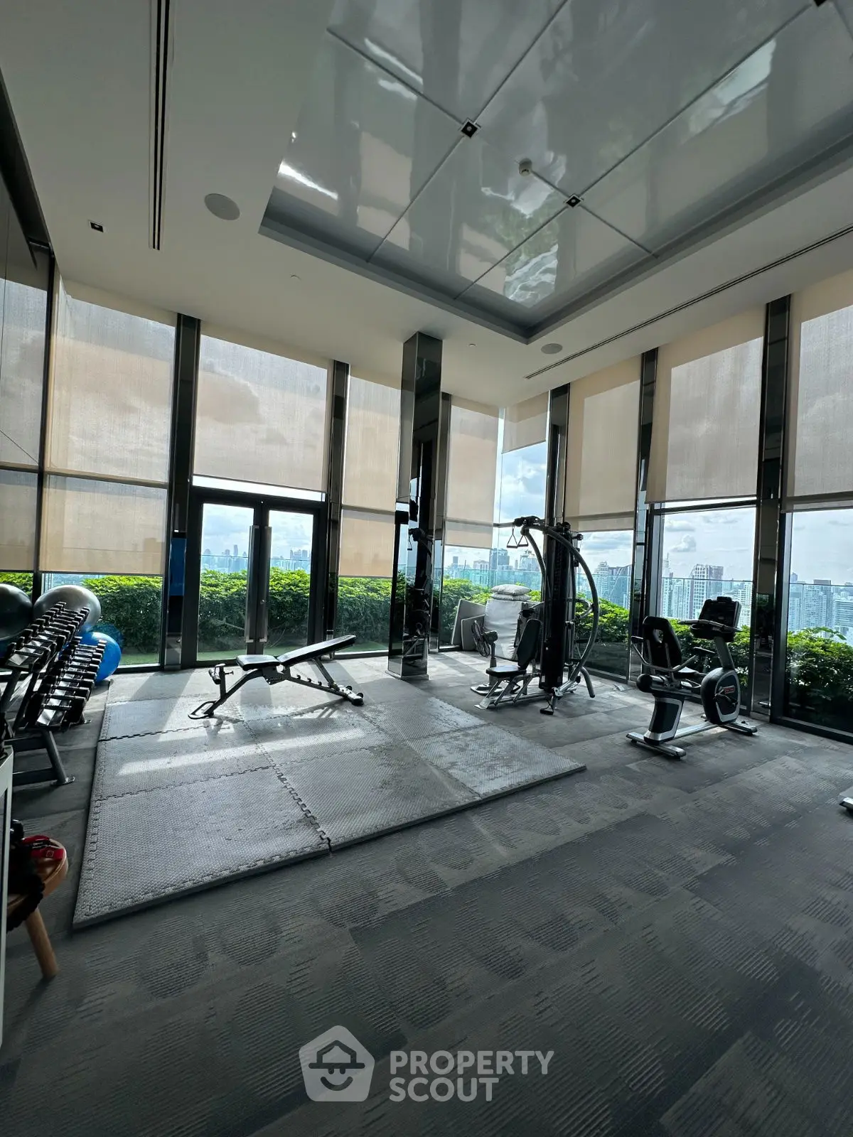 Luxurious high-rise gym with panoramic city views and modern fitness equipment.
