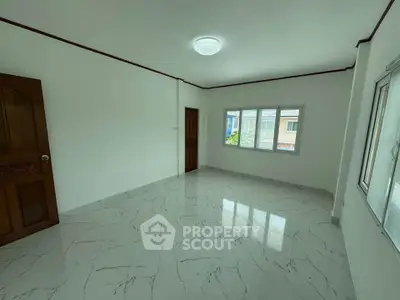 Spacious empty room with marble flooring and large windows in a modern home.