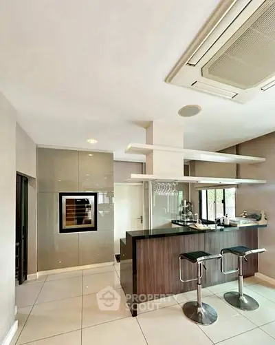 Modern kitchen with sleek bar counter and stylish stools in contemporary home.
