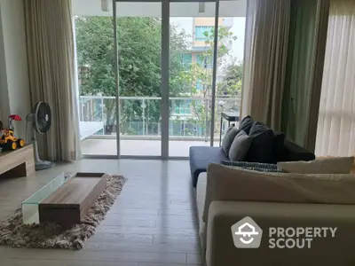 Spacious living room with modern decor and balcony view in a stylish apartment.