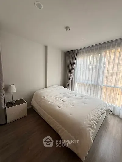 Cozy bedroom with modern decor and large window for natural light