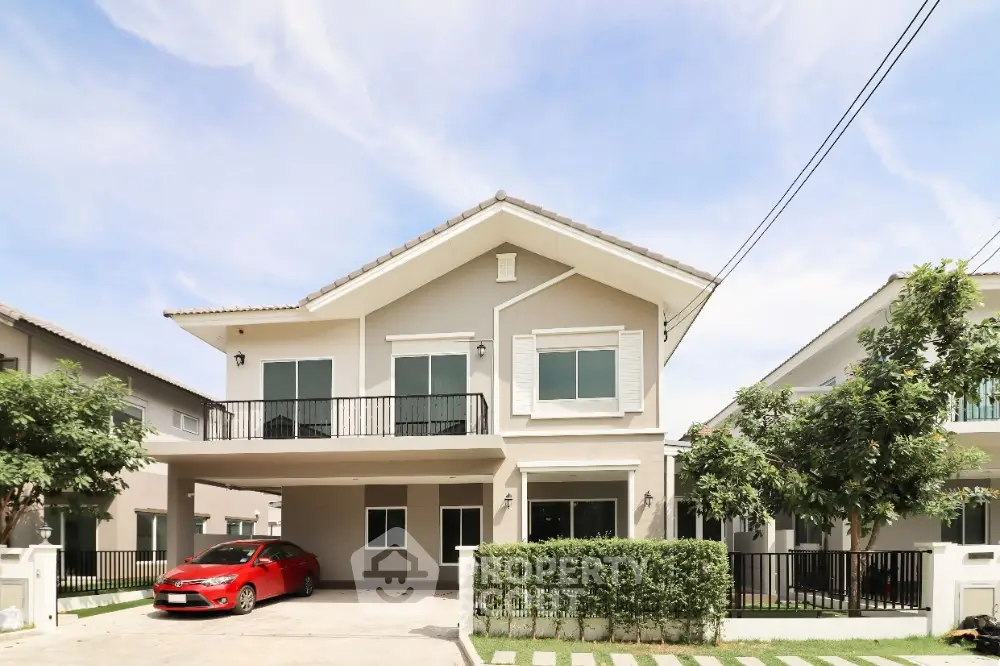 Modern two-story house with spacious driveway and red car parked, surrounded by lush greenery.