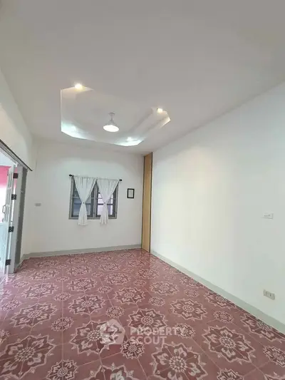 Spacious living room with unique ceiling design and patterned tile flooring