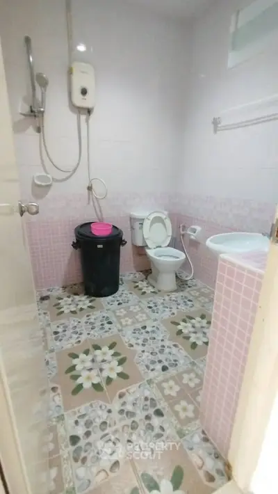 Charming bathroom with floral tile design and modern fixtures.