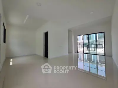 Spacious modern living room with large windows and glossy floors in a contemporary home.