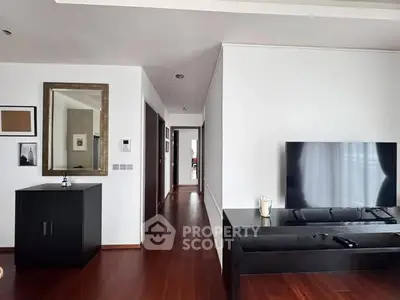 Modern living room with sleek wooden flooring and large TV setup
