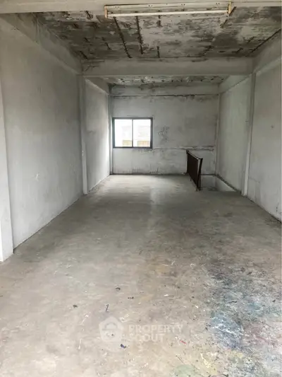 Spacious industrial-style room with concrete floors and large window