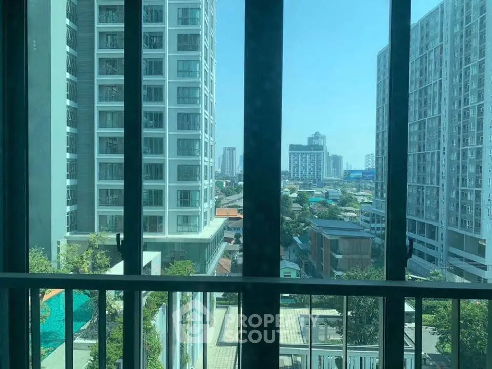 Stunning urban view from high-rise apartment window showcasing city skyline and modern architecture.