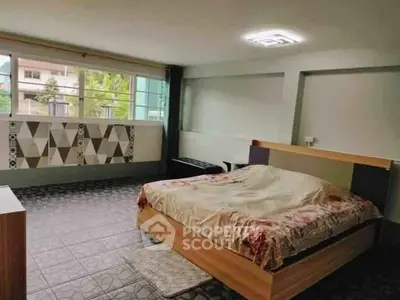 Spacious bedroom with modern design and large windows offering natural light