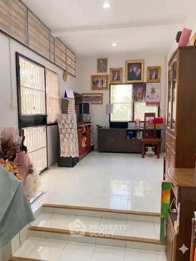 Charming living room with tiled floors, cozy furniture, and decorative wall art, perfect for family gatherings.